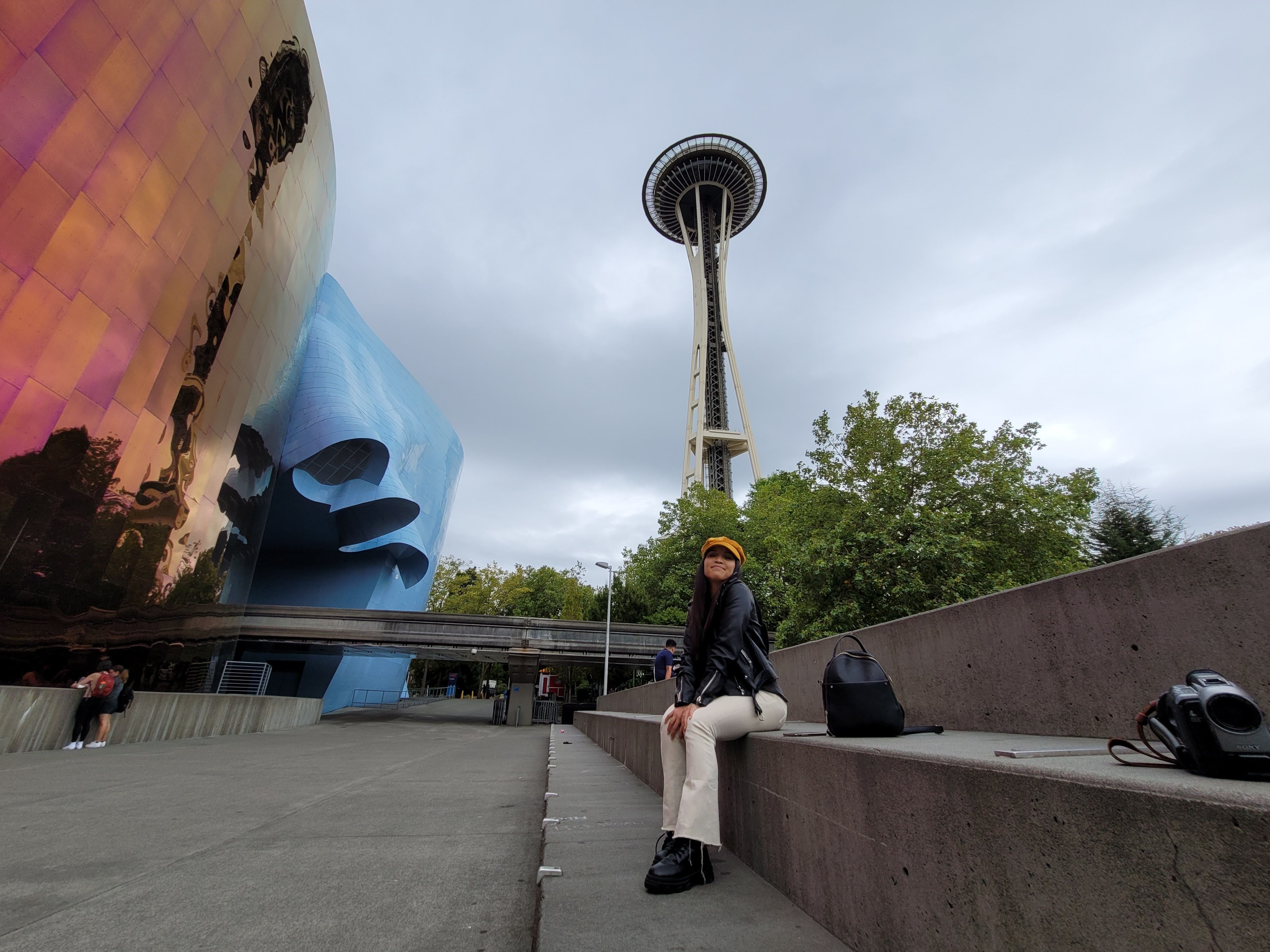 woman sitting on bench under seattle space needle