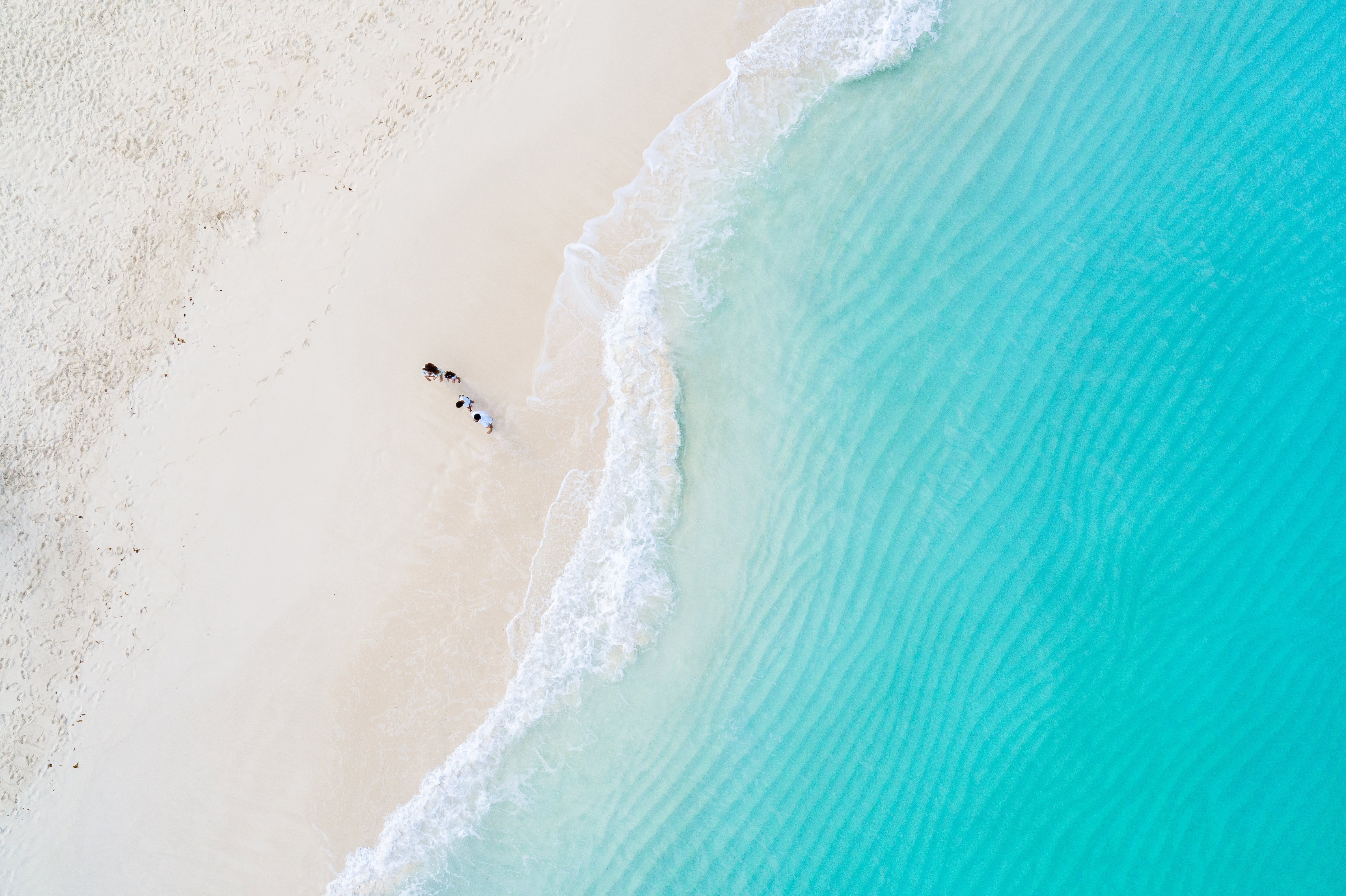 bird's eye view of family walking along ocean shore at Beaches Resorts