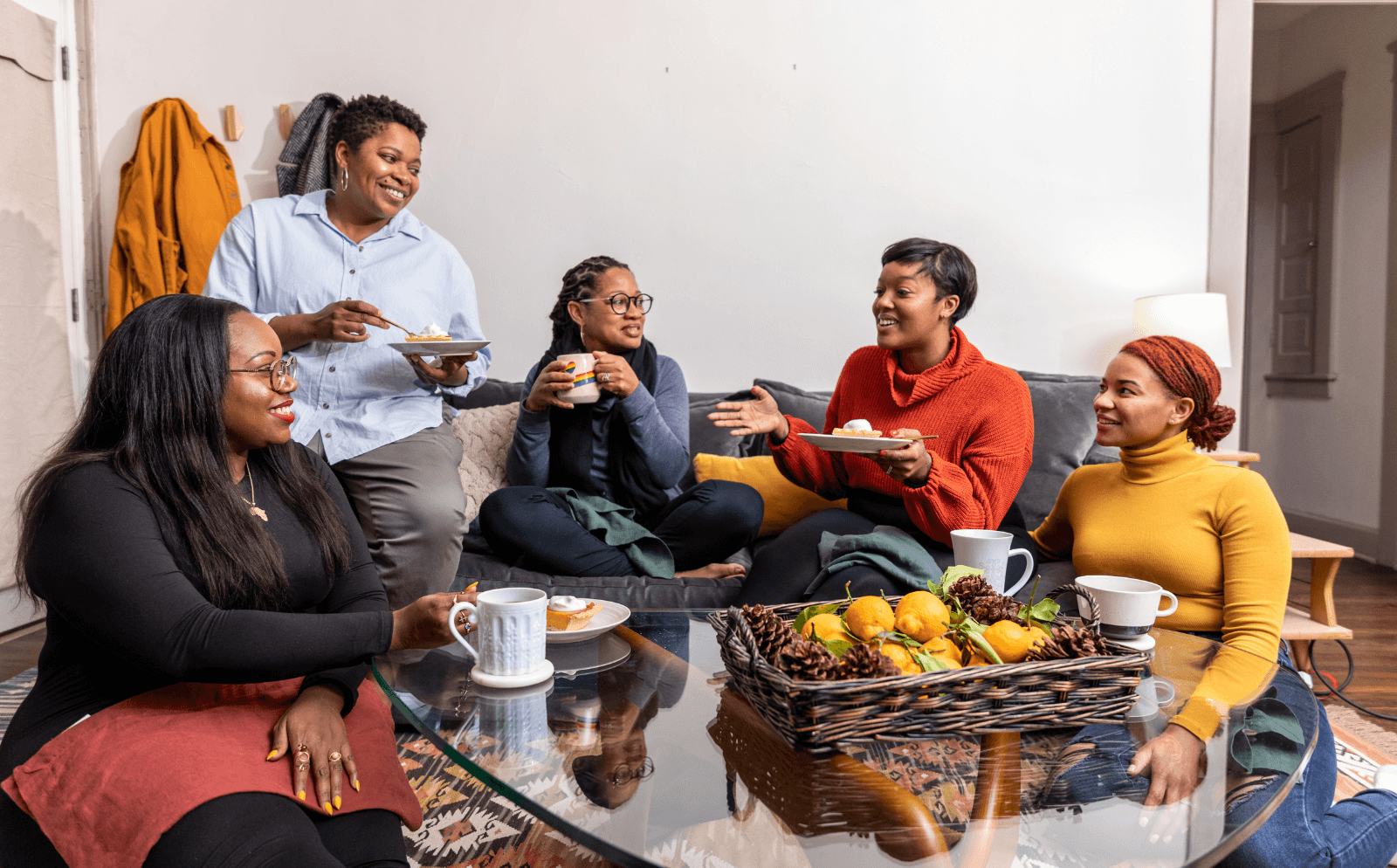group of five friends eating a meal at a table together