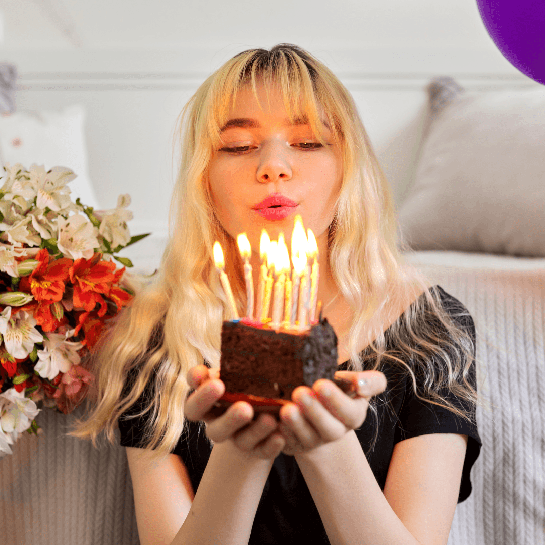 blonde girl blowing out candles on a cake