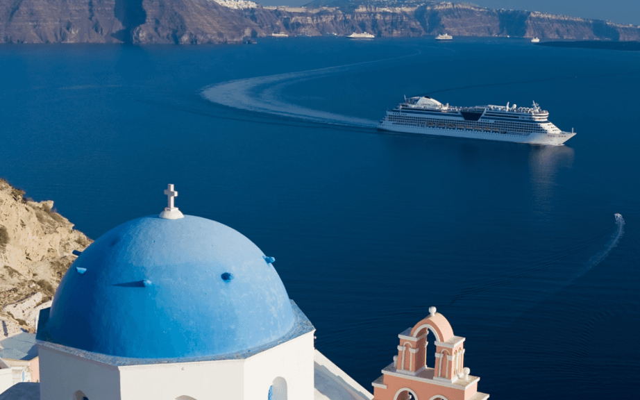 greek building looking out at ocean with a cruise ship going by