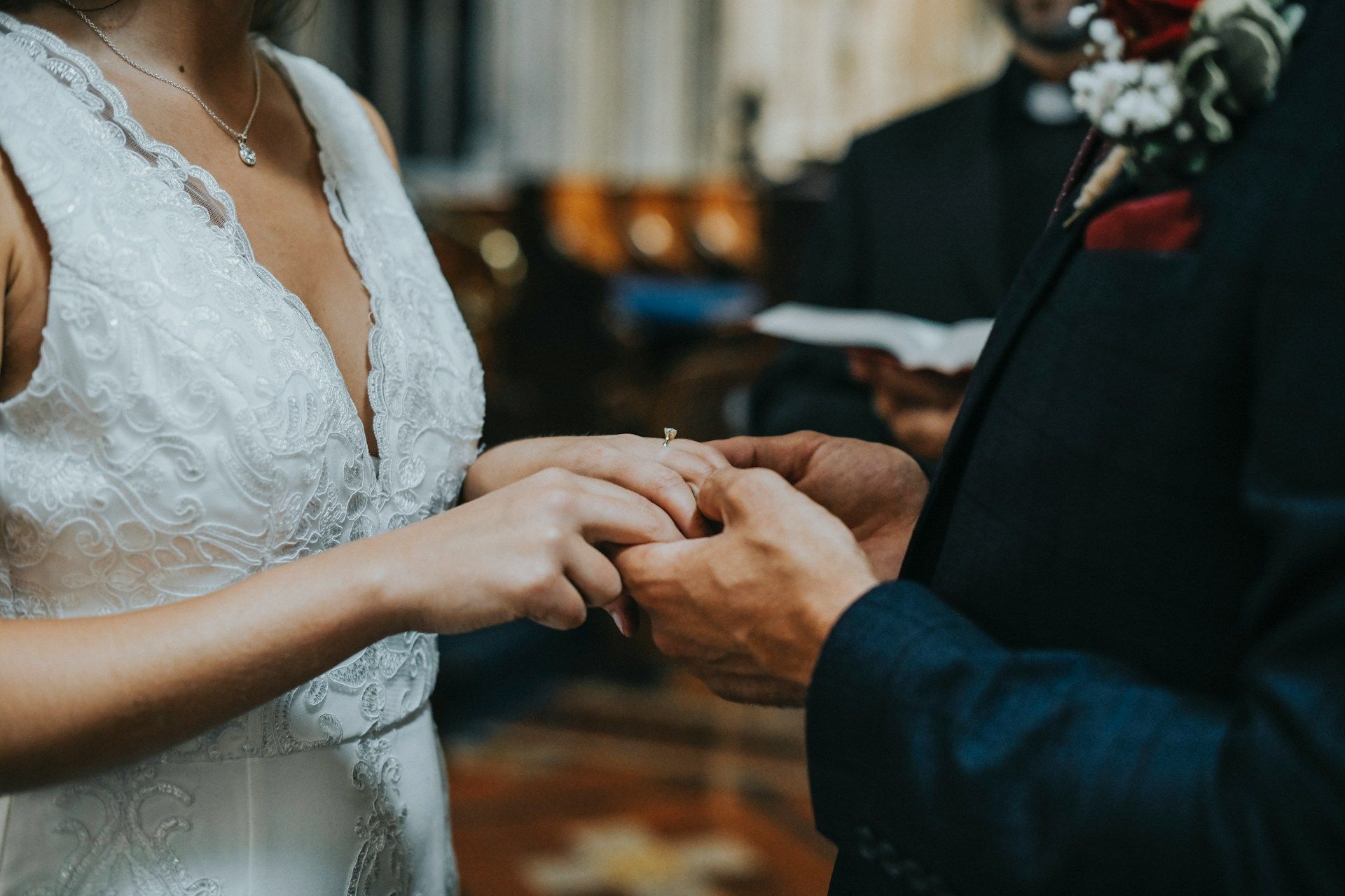 Bride placing a ring on the groom’s finger during the ceremony.