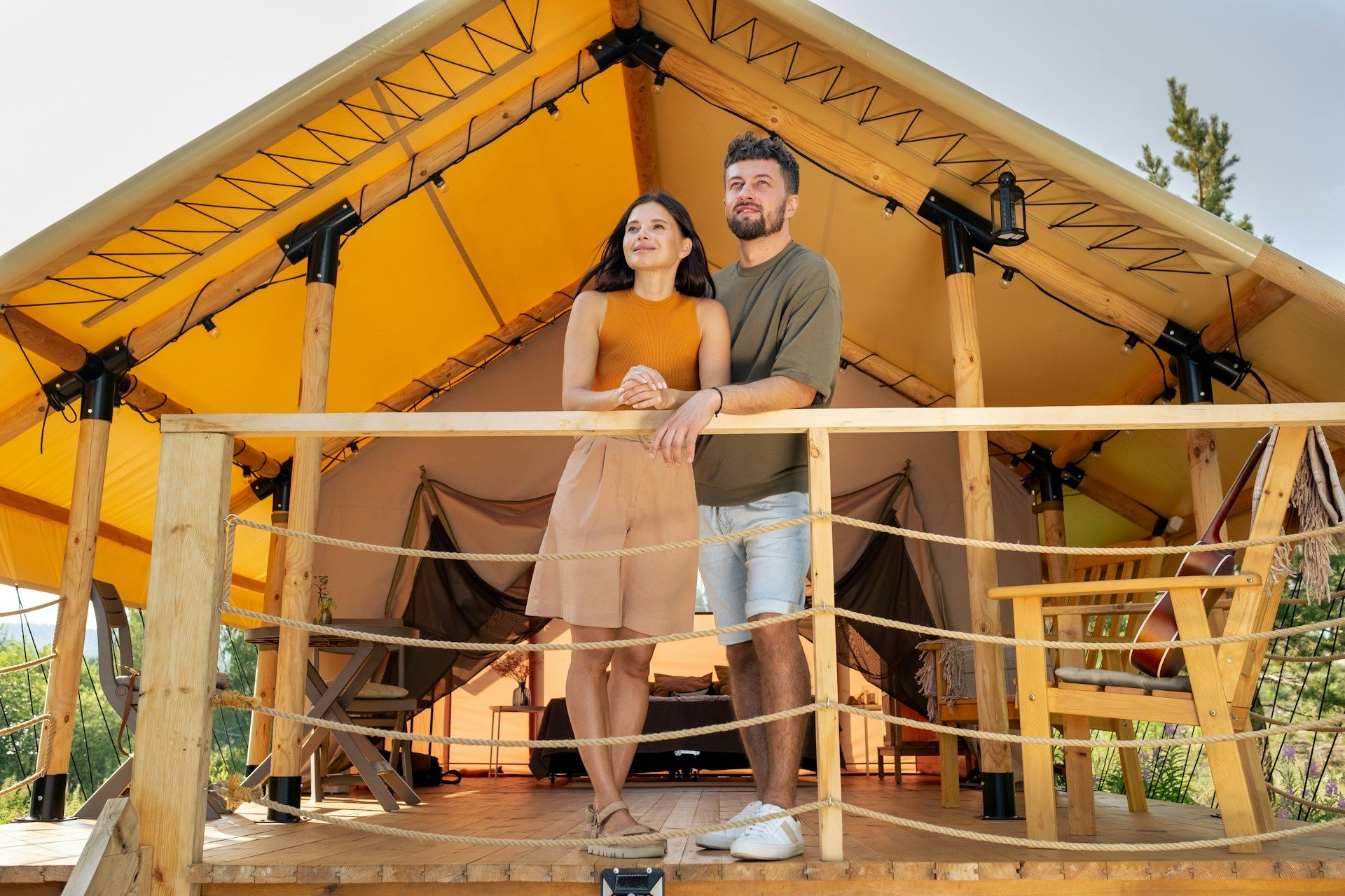 couple standing together looking out from hut balcony