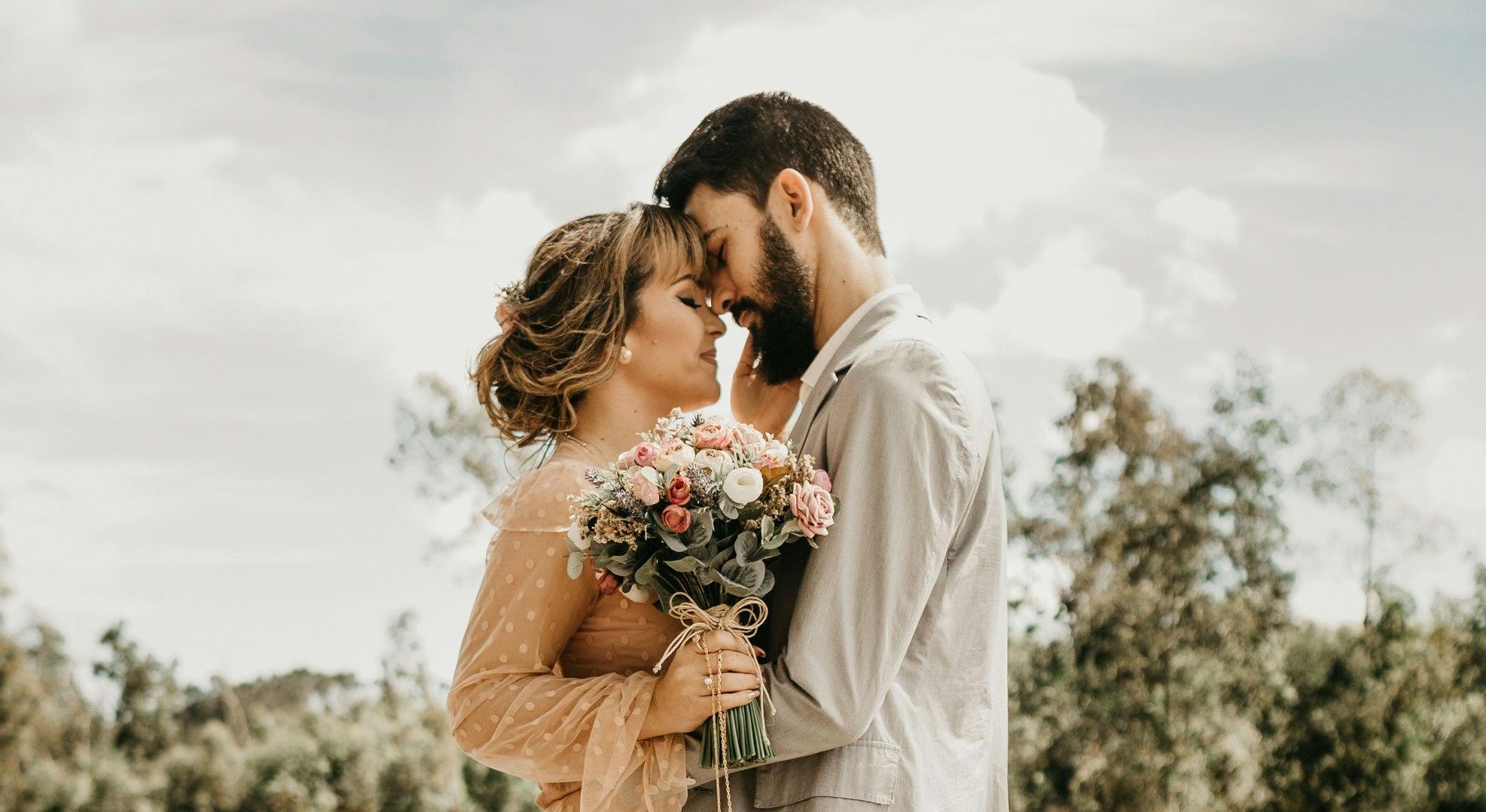 couple embracing on a dock with woman holding flowers