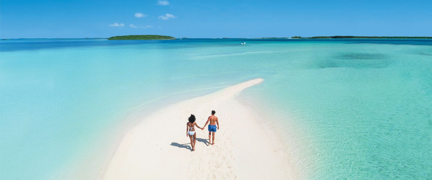 Couple holding hands walking on beach