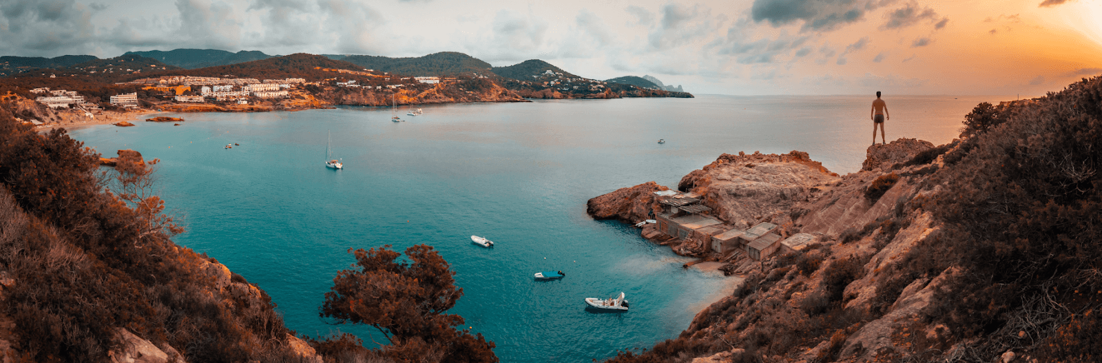 person standing on rock formations over ocean in spain